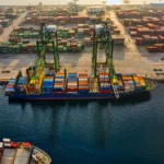 Foto udara pelabuhan Jakarta Utara dengan tumpukan kontainer warna-warni dan kapal kargo